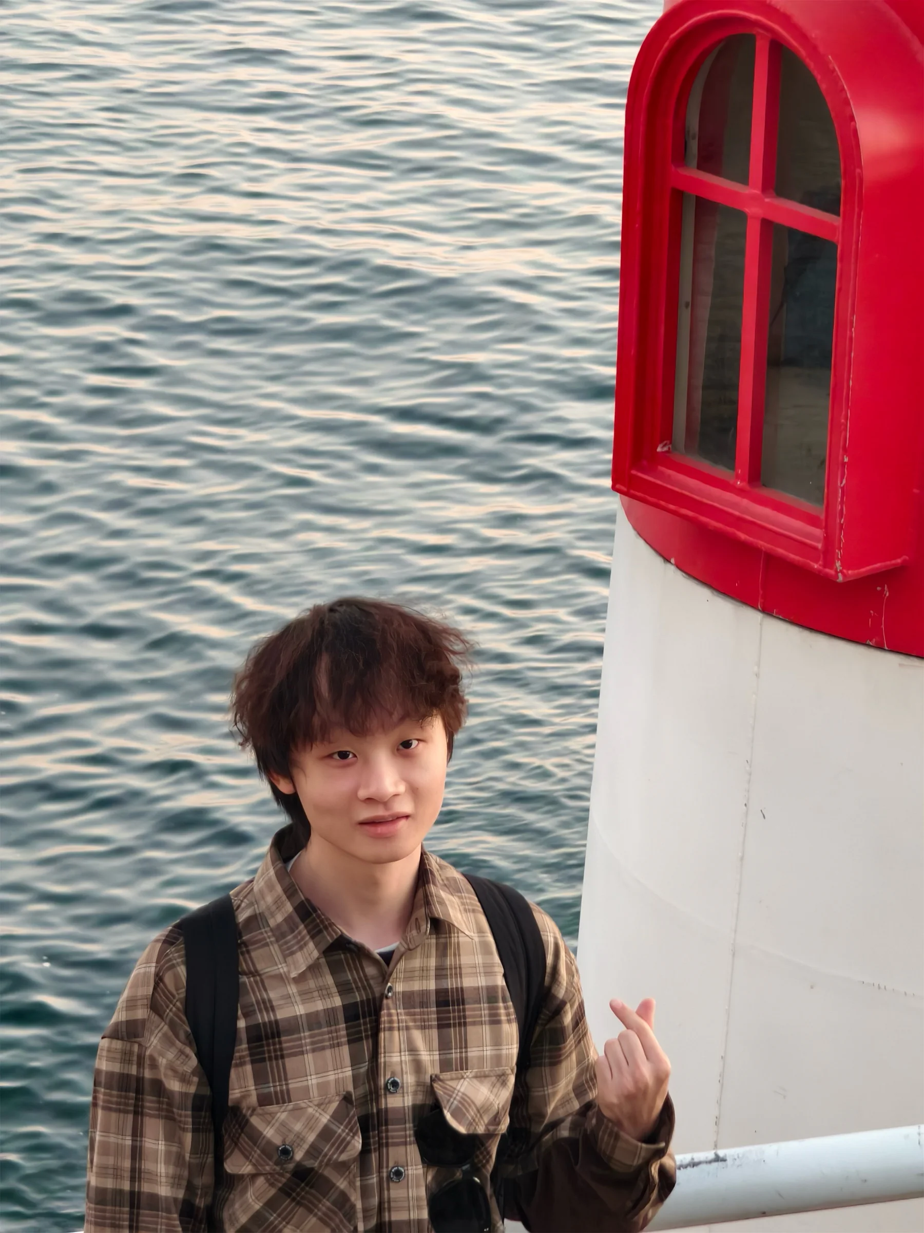 海边灯塔旁的人物照片